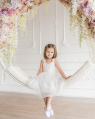 Little beautiful girl with a caret in a white dress on a white ring