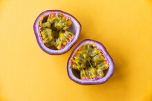 Two Halves Of Passionfruit Close-up On A Yellow Background. Tropical Fruits
