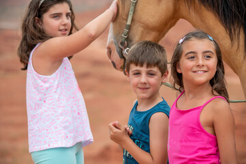 Wall Mural - Young girl riding touching horse in the beautiful Monument Valley