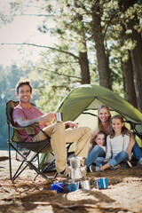 Wall Mural - Smiling family at campsite in woods