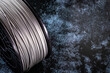 A coil of filament for 3d printing. Bright thermoplastic of grey color. Reel vertical view.