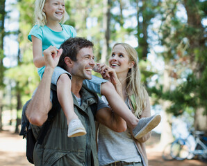 Wall Mural - Father carrying daughter on shoulders in woods