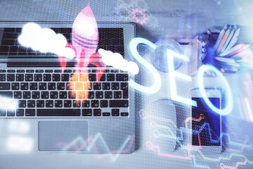 Double exposure of SEO drawing over study table background with computer. Concept of search. Top view.