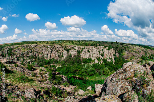 Stone gray canyon among green trees, river between the mountain. One of the Wonders of the World of Ukraine is the Act of Devil\'s Canyon. Traveling around the country by car, climbing, climbing