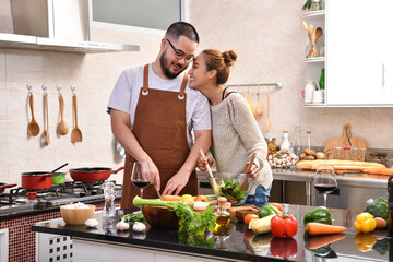 Wall Mural - Loving young Asian couple cooking in kitchen making healthy food together feeling fun