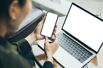 computer,cell phone mockup image.hand woman work using laptop texting mobile.blank screen with white background for advertising,contact business search information on desk in cafe.marketing,design