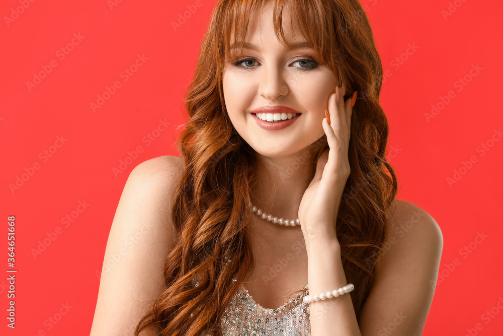 Beautiful young redhead woman on color background