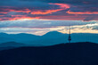 Canberra tower with colourful sunset and layers of clouds and mountains in the background