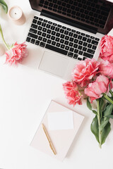 Wall Mural - Laptop, blank paper sheet card, pink peony tulip flowers on white table. Flat lay, top view minimal workspace desk