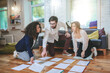 © zinkevych - Guy and two girlfriends in room on floor working on project
