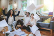 © zinkevych - Three young friends sitting on floor throwing up documents