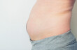 © ivan4es - Close up picture of  young man's fatty abdomen on isolated background. Guy wants to pump up the abs on his stomach.