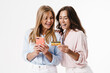 © Drobot Dean - Image of charming two women using mobile phone and holding credit card