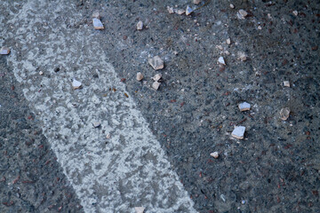 Close-up asphalt road with white edge line. Grainy road surface.