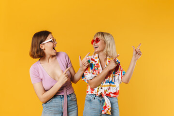 Poster - Portrait of two cheerful lovely girlfriends standing