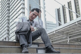 Fototapeta Pomosty - Asian middle aged businessman stressed due to jobless from economic recession.