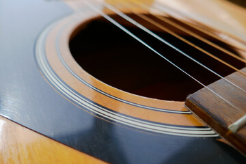 Wooden acoustic guitar, musical instrument, guitar strings.