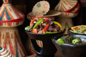 Wall Mural - Selective focus shot of delicious Ethiopian food with fresh vegetables on a wooden table