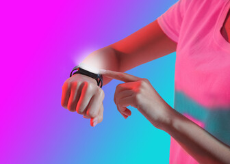 Smart device on hand. Girl in t-shirt presses button on smart watch with luminous screen