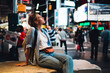 © BullRun - Young female traveler fascinated with Time square lights sitting on crowded street, thoughtful hipster girl looking at modern architecture of famous New York landmark shining with neon commercial.