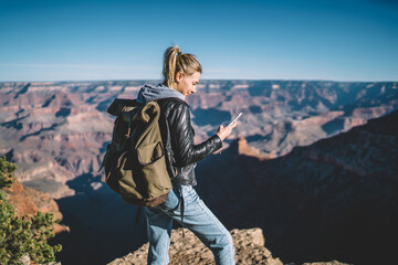 smiling female american tourist read message on smartphone satisfied with good data connection in mo