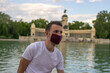 © Irene Castro Moreno - Photo of a young and attractive man wearing a face mask and sitting next to a beautiful and graan park isolated in nature