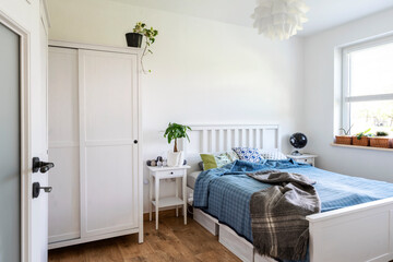 Wall Mural - Scandinavian design with white bedroom and wooden furniture. Stylish and cozy interior with bed ,window and white wall with copy space.