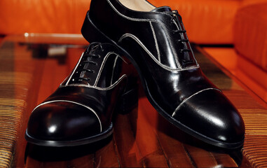 Elegant black leather men shoes on a red background