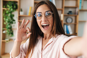 Sticker - Image of businesswoman gesturing ok sign while taking selfie photo