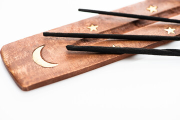 Wall Mural - close up view of aroma sticks on wooden stand with moon and stars on white background