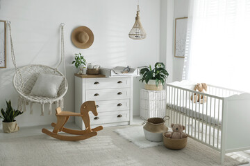 Poster - Chest of drawers with changing tray and pad near comfortable cradle in baby room. Interior design