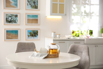 Stylish kitchen interior with teapot and cups on table