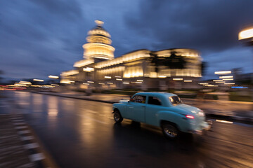 Old car on streets of Havana with colourful buildings in background. Cuba