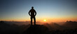 Man Silhouette reaching summit enjoying freedom and looking towards mountains sunset. Allgau Alps, Bavaria, Germany and Tyrol Austria.