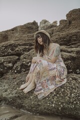 Wall Mural - Selective focus shot of a young caucasian female with tattoos wearing a dress and straw hat