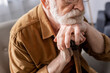 © LIGHTFIELD STUDIOS - cropped view of depressed senior man sitting and leaning on walking stick