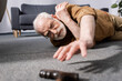 © LIGHTFIELD STUDIOS - selective focus of helpless senior man fallen on floor and trying to get walking stick