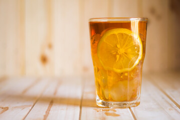 Wall Mural - Glasses of ice tea with lemon slices  on wooden background