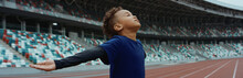 Cute Little Black Kid Boy Spreading His Hands On An Empty Stadium, Dreaming Of Becoming Professional Player, Soccer Star