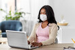 © Syda Productions - quarantine, remote job and pandemic concept - african american woman wearing face protective medical mask for protection from virus disease with laptop computer working at home office