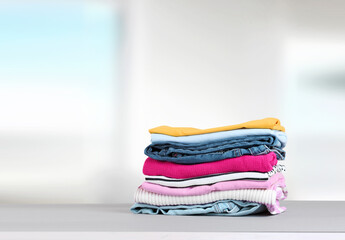 Wall Mural - Stack of colorful clothing,cotton folded clothes stacked.Apparel on table empty copy space.