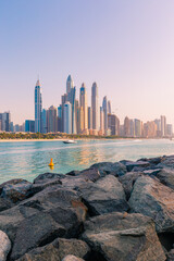 Wall Mural - Modern buildings of Dubai Marina view from Palm Jumeirah beachside with pink skies during sunset