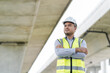 © Chanakon - Portrait engineer handsome man or architect looking construction with white safety  helme in construction site.. helmet in construction site.