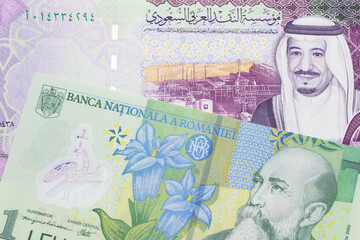 Wall Mural - A close up image of a one Romanian leu bank note with a colorful five riyal Saudi Arabian bank note in macro