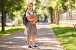© Studio Romantic - Back to school. Happy schoolgirl smiles while standing on the road to school in the morning.