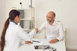 © Studio Romantic - Smiling mature male patient makes doctor shaking hands at clinic office