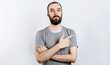 © Daria Lukoiko - Handsome brunette man with a beard points a finger at a place for advertising on a white background