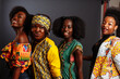 Four young beautiful African fashion models have fun and laughing in traditional dress. Women from the Congo Republic, Ivory Coast, and Zimbabwe