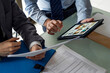 © PhotoAlto - Businessmen holding document and digital tablet