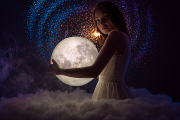 Wall Mural - beautiful girl holds the moon in her hands, against the background of stars, femininity and astrolog